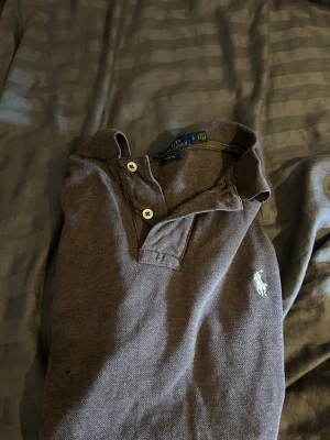 Mörkbrun pikétröja från Polo Ralph Lauren - Tja! Säljer en av mina polo pikéer med ett litet hål i säg lite under bröstet vid fler funderingar är de bara höra av sig🙌viktigt att tänka på är att den är storlek L men passar S-M funkar på mig som är 183 och du kan även va kortare🤞✌️