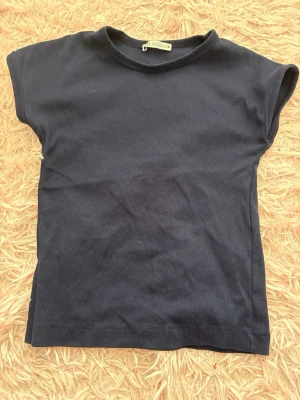 Mörkblå t-shirt från ZARA - En enkel och stilren mörkblå t-shirt från ZARA. T-shirten har korta ärmar och rund halsring. Perfekt basplagg att matcha med allt.