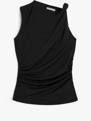 Svart asymmetrisk ärmlös topp - Snygg svart topp med asymmetrisk skärning och ett twistat axelparti. Toppen är ärmlös och har draperade detaljer i sidan som ger en cool och modern look. Perfekt att styla med jeans eller kjol för en trendig outfit.