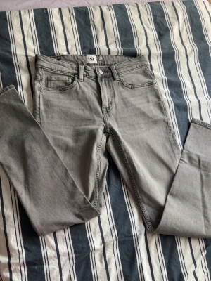 Grå jeans från 157 - Säljer ett helt nya grå jeans med rak passform och klassisk femficksdesign. Jeansen har normal midja och är tillverkade i ett mjukt denimtyg. Perfekta för dig som gillar en enkel och stilren look.