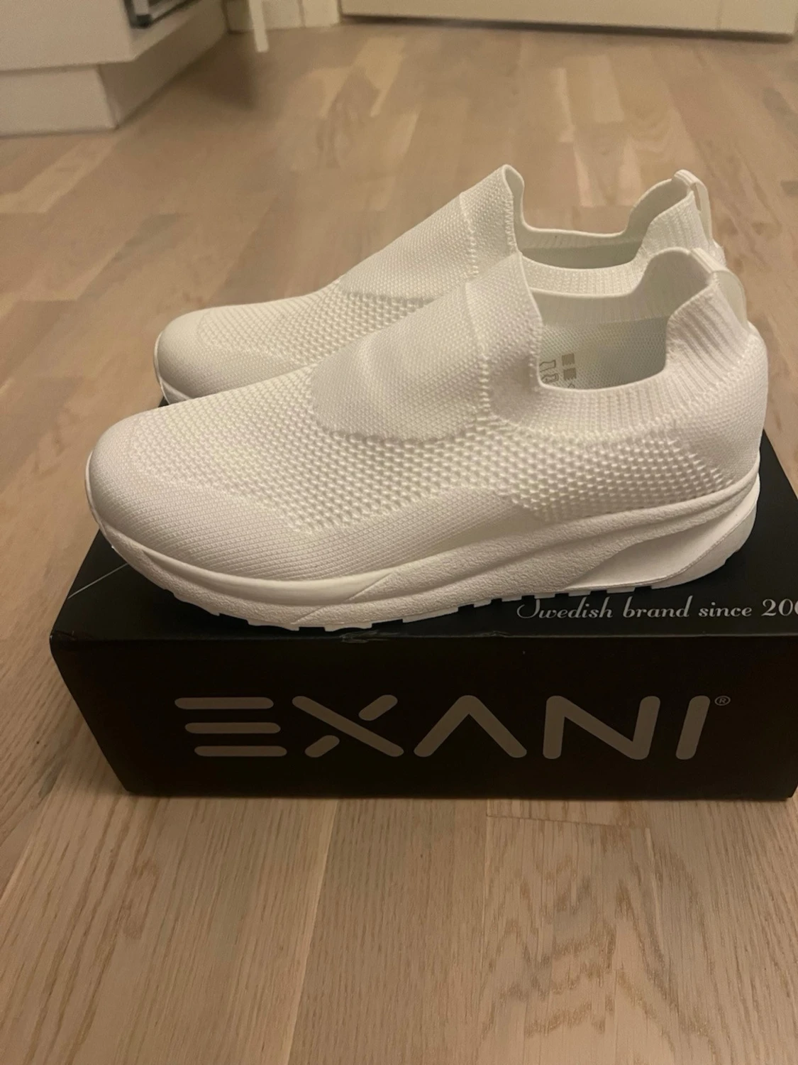 Vita slip-on sneakers från Exani