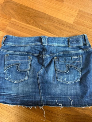 Blå jeanskjol  - Säljer en snygg blå jeanskjol från MNG. En knapp har trillat av men den går fortfarande att använda.💕