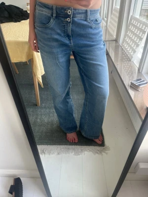 Blå baggy jeans med låg midja - Säljer ett par ljusblå jeans med raka ben och låg midja. Jeansen har dubbla knappar i linningen och klassiska fem fickor. Materialet är denim i bomull och passformen är avslappnad och trendig. Aldrig använda.  Pris kan diskuteras! 