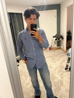 Blårutig skjorta från Polo Ralph Lauren - Säljer en klassisk blårutig skjorta från Polo Ralph Lauren med button-down krage och broderad logga på bröstet. Skjortan har långa ärmar och vita knappar. Tillverkad i mjuk bomull och har en slim fit passform. Tveka inte på att skriva vid frågor eller funderingar🌟😊