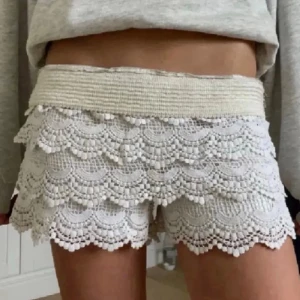Vita virkade shorts med volanger - Supersöta vita/beiga shorts med flera lager virkade volanger och elastisk midja 🤍🤍 i storlek M men passar S om man vill bära dem lowrise!!