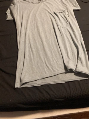 Ljusgrå t-shirt med bröstficka - En stilren ljusgrå t-shirt med rund halsringning och en praktisk bröstficka på vänster sida. T-shirten har korta ärmar och är tillverkad i mjuk bomull, perfekt för en avslappnad look perfekt Sov T-shrt Inte min stil ändas swhis Hämtas i Västerås Flocksta 3