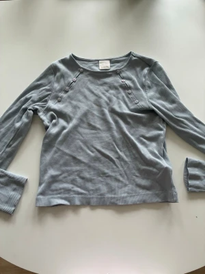 Jättesöt topp från Zara - Säljer en ljusblå topp från Zara i storlek 156cm. Den är jättesöt med knappar och jag säljer den för att jag har växt ut den.