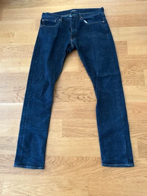 Mörkblå jeans från Polo Ralph Lauren - Snygga mörkblå jeans från Polo Ralph Lauren med klassisk femficksmodell och raka ben. Jeansen har kontrastsömmar och bälteshällor. Perfekta för dig som gillar tidlös och stilren denim.