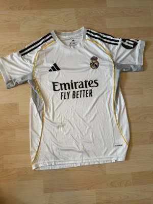 Real Madrid Hemma Kit 2025/26 - Stilren fotbollströja i helt nytt skick. Tröjan är inte använd en endaste sekund.