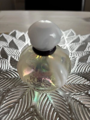 Pure Poison Dior parfym - Säljer parfym från Dior ”Pure Poison” i en pärlemorskimrande glas och rund vit kork. Flaskan har en mjukt rundad form och texten 'Poison' syns på framsidan. Perfekt som en snygg detalj på sminkbordet också.