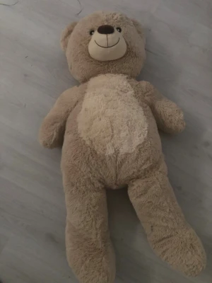 Stor beige nallebjörn - Mysig och stor nallebjörn i beige plysch med ljusare mage och ansikte. Den har ett stort leende, runda öron och mjuk stoppning. Perfekt som gosedjur eller dekoration i rummet. betalning via vanlig swish!💗