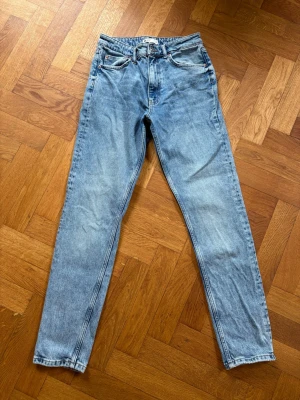 Ljusblå jeans från GinaTricot  - Snygga ljusblå jeans från GinaTricot med klassisk femficksdesign. Jeansen har raka ben och är tillverkade i ett slitstarkt denimtyg. Perfekta för en avslappnad och trendig look.