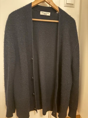 Cardigan Marc O’Polo - Stilren cardigan från Marc O’Polo, väldigt sällsynt och svår att hitta. Storlek S men passar också M. Materialet är Alpacka Ull och den är i väldigt bra skick. Vid snabb affär kan priset justeras. (OBS!) Inga byten.
