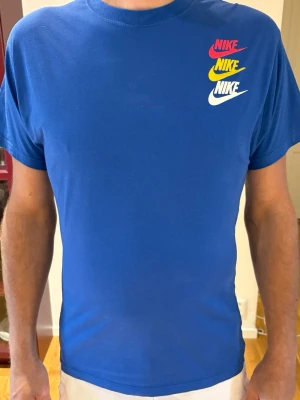 Blå Nike t-shirt med färgglad logga stl S - Snygg blå t-shirt från Nike