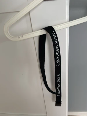Svart bälte från Calvin Klein Jeans - Snyggt svart bälte från Calvin Klein Jeans med vit logga längs hela bandet | längd: 85-90cm | pris  kan diskuteras!