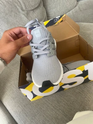Grå Adidas Ultraboost sneakers - Snygga grå Adidas Ultraboost sneakers med stickad ovandel och vit Boost-sula. Skorna har aldrig använts dem är helt nya, storlek 42 passar 43 också 