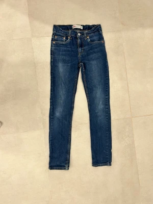 Mörkblå skinny jeans - Snygga mörkblå skinny jeans med klassisk femficksdesign och lätt slitna detaljer. Jeansen har normal midja och smal passform hela vägen ner. Perfekta till en avslappnad streetstyle-look.