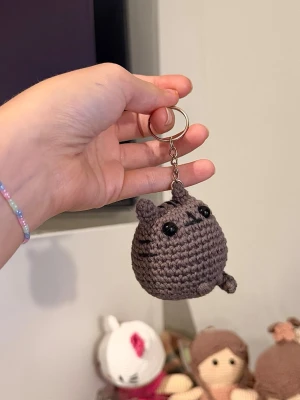 Pusheen nyckelring beställning - Handvirkad nyckelring inspirerad av Pusheen. Helt ny och virkas på beställning. Små variationer kan förekomma eftersom varje nyckelring är handgjord.