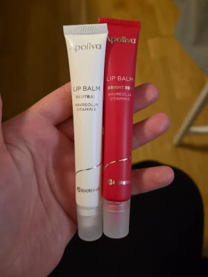 Apoliva Lip Balm duo - Två läppbalsam från Apoliva, ett i neutral färg och ett i bright red. Båda innehåller havreolja och vitamin E för extra vårdande känsla. Tubformat med genomskinliga lock, perfekt att ha i väskan för återfuktade läppar.