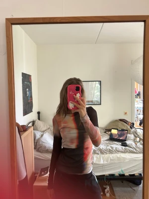 Mesh topp från Weekday  - Säljer en långärmad mesh topp från Weekday med abstrakt färgblocksmönster i svart, rött, beige och blått. Toppen är genomskinlig!