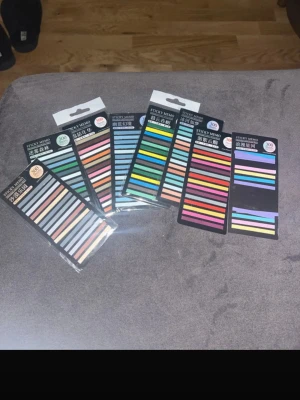 Flerfärgade sticky notes set - Säljer ett set med sex förpackningar sticky notes i olika färger och nyanser. Varje förpackning innehåller smala, rektangulära lappar perfekta för att markera sidor eller göra anteckningar. Passar bra till skola, jobb eller planering.