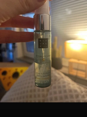 Rituals The Ritual of Jing parfym - En fräsch och lugnande parfym från Rituals, The Ritual of Jing. Kommer i en genomskinlig glasflaska med silverfärgad spraykork. Perfekt att använda både som body mist och kuddspray. Flaskan rymmer 20 ml och har en stilren design.