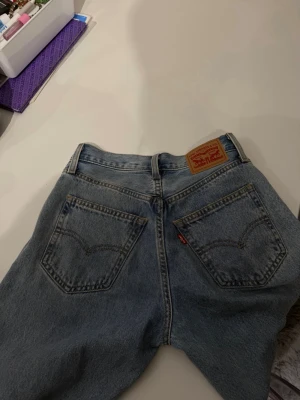 Levi's ljusblå raka & baggy jeans - Klassiska ljusblå jeans från Levi's med raka ben, baggy och hög til medel midja. Jeansen har fem fickor, bälteshällor och den ikoniska röda Levi's-lappen på bakfickan samt läderpatch i midjan. Perfekta för en avslappnad och trendig look.