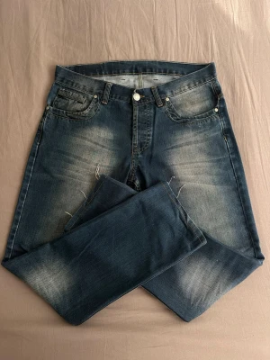 Hugo Boss jeans - Säljer ett par mörkblå jeans med raka ben och snygga slitningar på låren och knäna. Jeansen har klassisk femficksmodell, knappgylf och subtila tvättade detaljer för en avslappnad look. Perfekta till en streetwear-outfit. 32/32