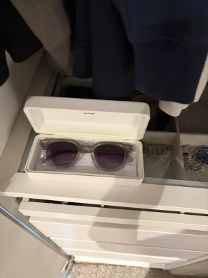 Grå transparenta solglasögon CHIMI - Säljer ett par stilrena solglasögon från CHIMI med transparent grå båge och mörka glas. Klassisk fyrkantig form som passar till det mesta. Kommer med originalfodral. Perfekta för dig som vill ha en clean och modern look.