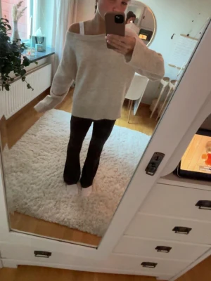 Beige oversized off shoulder tröja - Mysig beige oversized tröja med off shoulder-design och långa ärmar. Tröjan har en avslappnad passform och är perfekt för en chill look. Materialet ser ut att vara mjukt och skönt, troligen bomull eller en bomullsblandning.