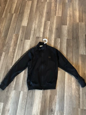 Svart track top från Fred Perry - Fred Perry track top, storlek m, knappt använd. Priset kan diskuteras vid snabb affär!