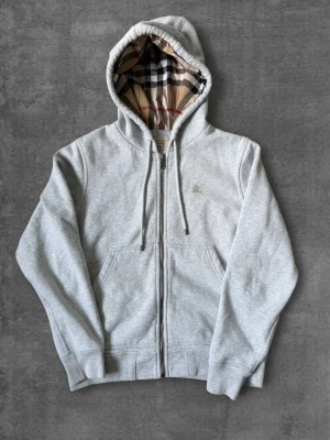 Grå Burberry zip hoodie  - Tjena! Säljer denna sköna burberry zip hoodien. Knappt använd, skicket är 10/10. Medföljer taggar osv. Vid frågor kontakta gärna! Mvh Adam