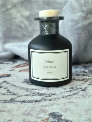 Doftdiffuser Sea Grass 100 ml - Snygg doftdiffuser i svart glas. Flaskan har en enkel, modern design och är försedd med kork. Perfekt för att sprida en fräsch doft i hemmet.