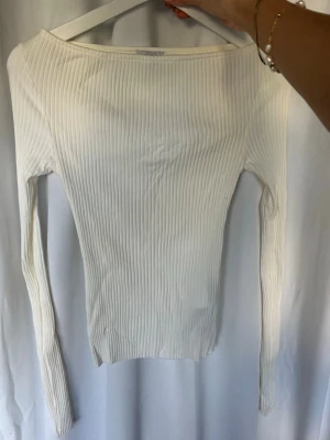 Vit ribbad långärmad topp Amisu - Säljer en vit ribbad långärmad topp från Amisu i storlek XS. Toppen har en tight passform och är tillverkad i ett mjukt, stretchigt material som sitter snyggt på kroppen. Perfekt att styla med jeans eller kjol för en clean look.