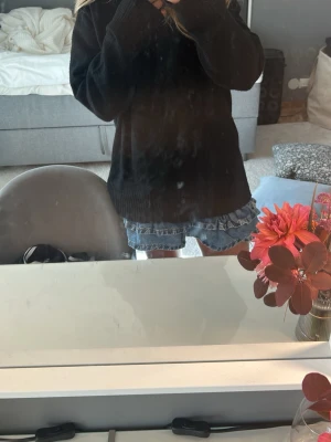 Blå jeansskort med volangdetaljer - Supersöt blå jeansskort med dubbla volanglager och klassiska fickor fram. Skorten har en feminin och trendig look med råa kanter och normal midja. .