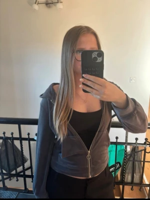 Mörkgrå zip hoodie - Mysig mörkgrå hoodie med dragkedja framtill och huva. Tröjan har långa ärmar och en avslappnad passform, perfekt att slänga på sig över en t-shirt. Passar till både chill och streetwear-stil. Skönt material