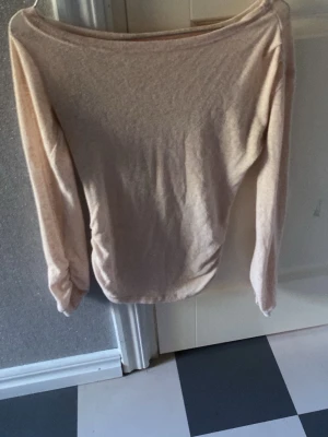 Ljusrosa långärmad ensidig off-shoulder topp  - Säljer en enkel och stilren rosa långärmad topp, något offshoulder halsringning. Toppen har en mjuk känsla och är perfekt att matcha med jeans eller kjol. Passformen är normal och materialet känns som bomull eller en bomullsblandning.