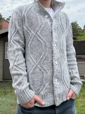 Stickad cardigan  - Riktigt clean stickad cardigan med knappar i en fin grå färg. Passar till det mesta. Storlek L men sitter som M. Fint skick.