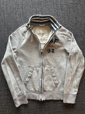 Abercrombie & fitch zip up ~ sällsynt  - Säljer nu denna sjukt snygga Abercrombie & Fitch zip up hoodien | st M ~ 175–185cm | OBS! Sliten design från fabrik som ger den en unik vintage-look | passar perfekt nu till kyligare dagar! Modellen produceras inte längre och är därav väldigt sällsynt. Kan även gå ner lite i pris vid snabb affär🍁🫶