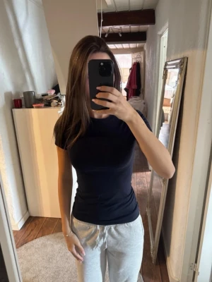 marinblå intimissimi t-shirt - En enkel och stilren marinblå t-shirt med rund hals och korta ärmar. T-shirten har en normal passform och är tillverkad i mjukt bomullsmaterial, perfekt för en avslappnad look.