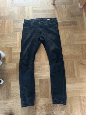 Mörkblå jeans från Lee - Säljer ett par mörkblå jeans från Lee med klassisk femficksmodell och raka ben. Jeansen har snygga slitningar och Lee-logga på knapp och etikett. Materialet är mjukt denim som sitter skönt och passar till många olika stilar.
