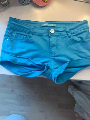 Turkosa skitsnygga lågmidjade jeansshorts - Säljar tyvärr shortsen för att midjan är för stor. Det står size 40 med n det motsvarar s i storlek 