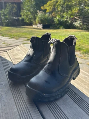 Svarta ridskor med stålhetta - Säljer ett par svarta ridskor som har stålhetta i sig. Det betyder alltså att de är hårda så att det ej gör ont när hästen kliver på foten🥰 bra skick och andvända i ungefär 1,5 år. Priset kan diskuteras 