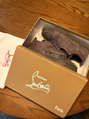 Christan Loubutin grå  - Säljer ett par grå sneakers i mocka från Christian Louboutin. Endast använda 3 gånger då jag har ett annat par, finns knappt spår av användning på skorna så dem är i mycket bra skick