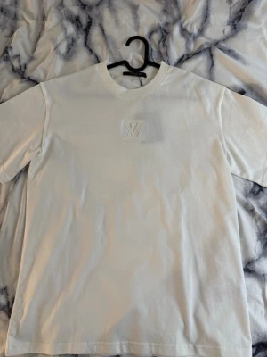T- shirt  - Säljer en stilren vit t-shirt med rund hals och korta ärmar. Väldigt fin i storlek S men passar mer som M eller om du vill ha den lös så är den perfekt.            På bröstet sitter loggan och logga som ger en exklusiv känsla. 