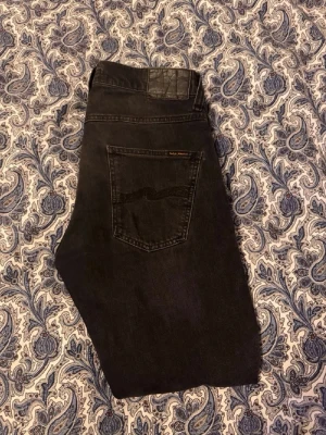 Svarta Nudie jeans - Svarta nudie jeans, modellen är grim tim och färgen Dark Cove. W30 L30.