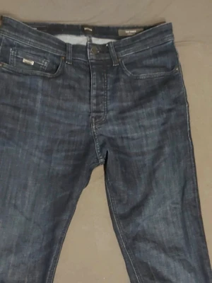 Mörkblå raka jeans från Hugo Boss - Säljer ett par mörkblå jeans från Hugo Boss med rak passform och klassisk femficksdesign. Jeansen har subtila slitningar och kontrastsömmar för en snygg look. Perfekta till vardags och passar till det mesta. Pris kan diskuteras 