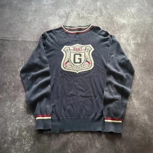 Mörkblå GANT sweatshirt i 2000-talsstil för herrar i storlek L - Tidlös modell och bekväm passform.  Mått 📏 Armhåla till armhåla: 52 cm Längd från kragen: 64 cm Ärmlängd från axeln: 69 cm Måtten finns även på bilderna  Skickas inom ett dygn Spara på priset och frakten genom att sätta ihop ett paket Mer information finns på min profil  20-443