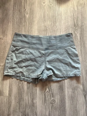 Ljusblå shorts  - Säljer ett par ljusblå shorts med två bakfickor. Shortsen har en enkel design utan synliga knappar eller dragkedja framtill och är gjorda i mjukt tyg. 