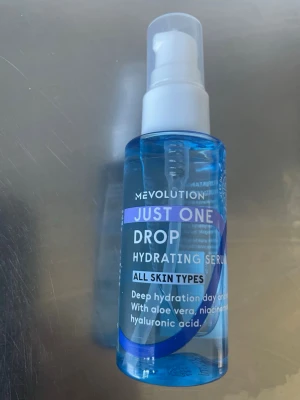 Mevolution Just One Drop Hydrating Serum - Återfuktande serum från Mevolution i blå plastflaska med pump. Passar alla hudtyper och innehåller aloe vera, niacinamid och hyaluronsyra för djup återfuktning. Perfekt för daglig hudvårdsrutin.